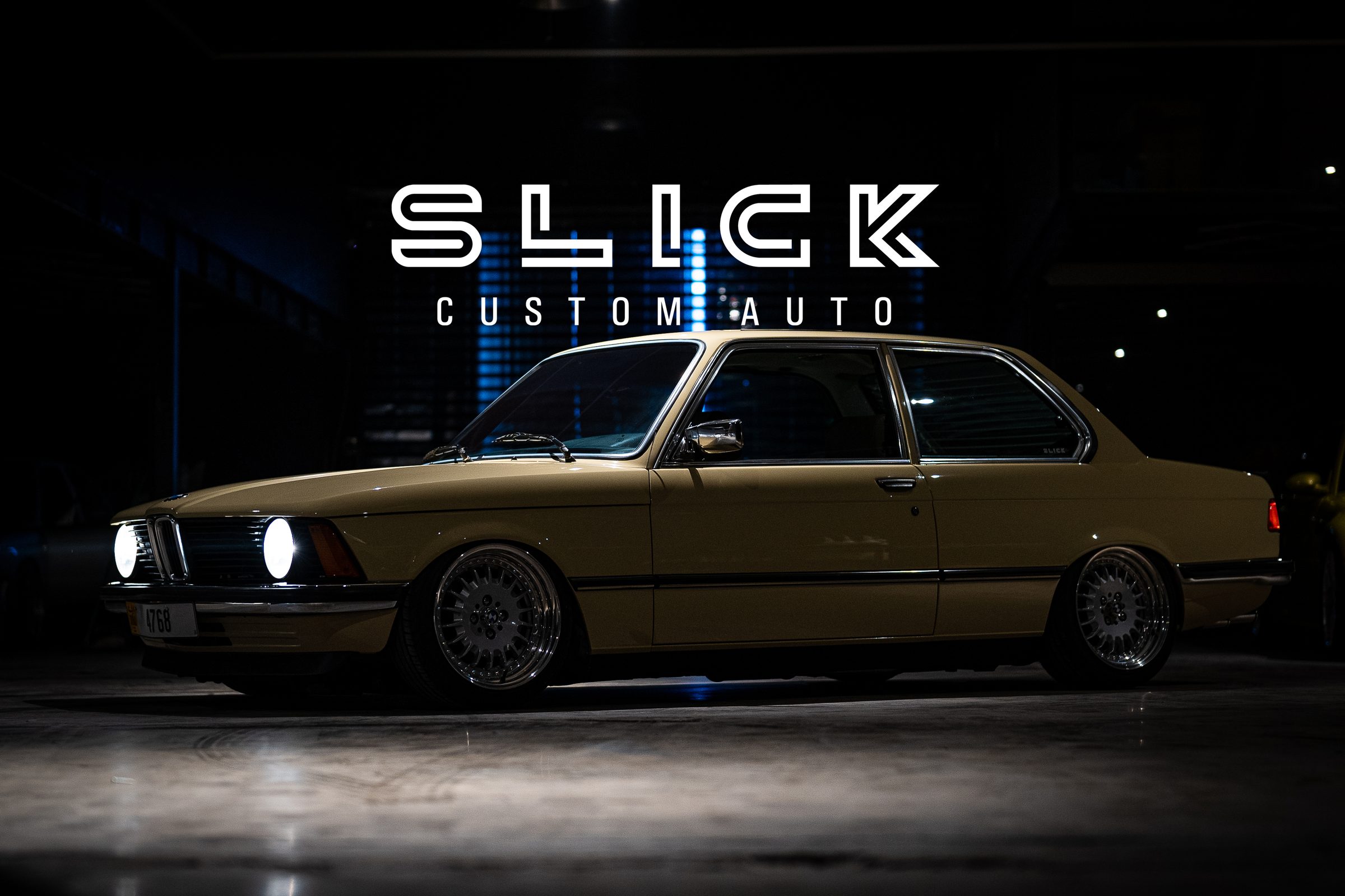 A restored classic BMW E21 photographed in the dark studio