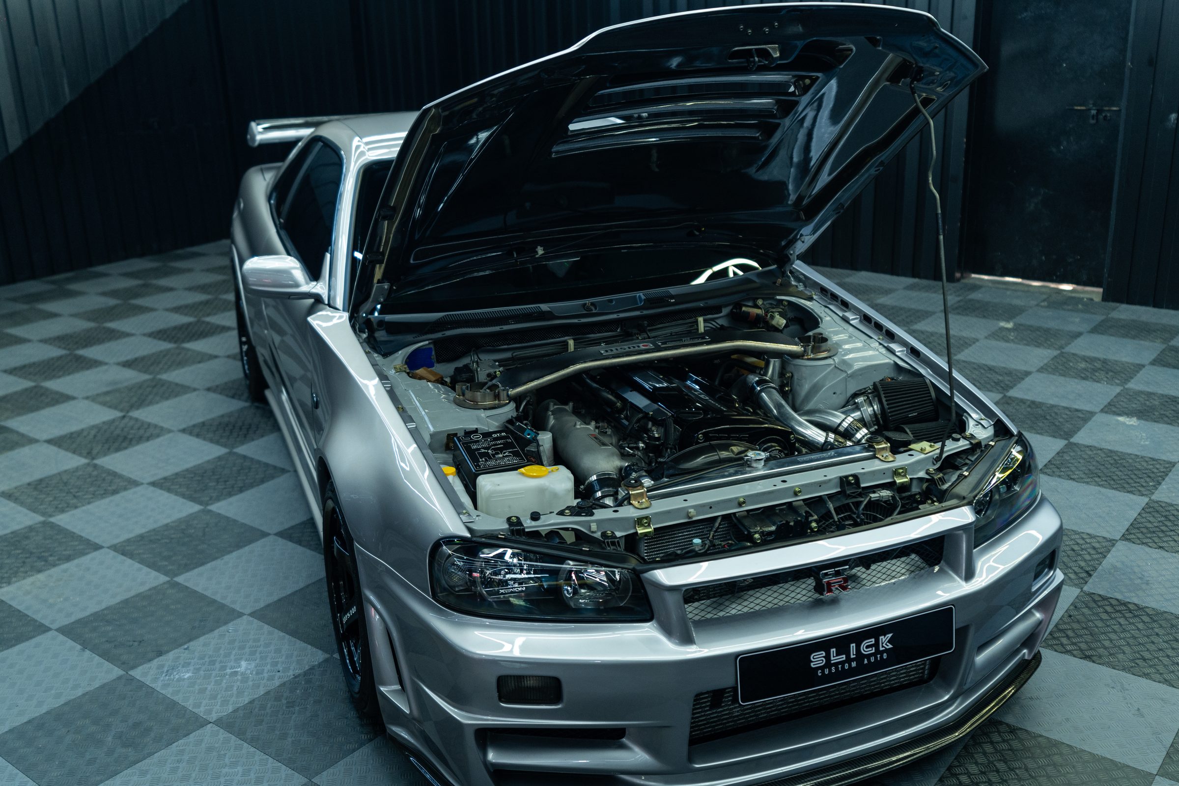 The engine bay of a Nissan Skyline opened up on the workshop floor