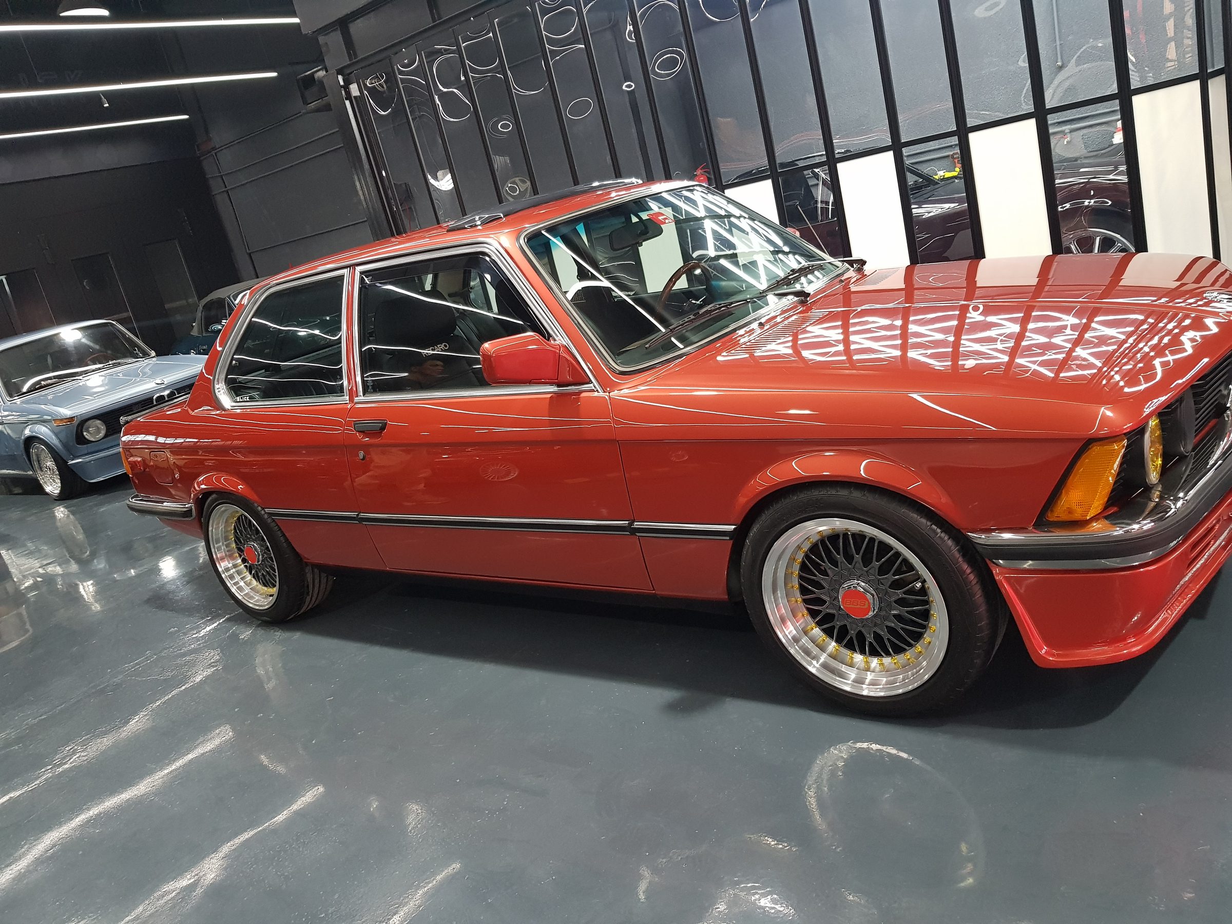 An orange classic BMW E21 in the workshop