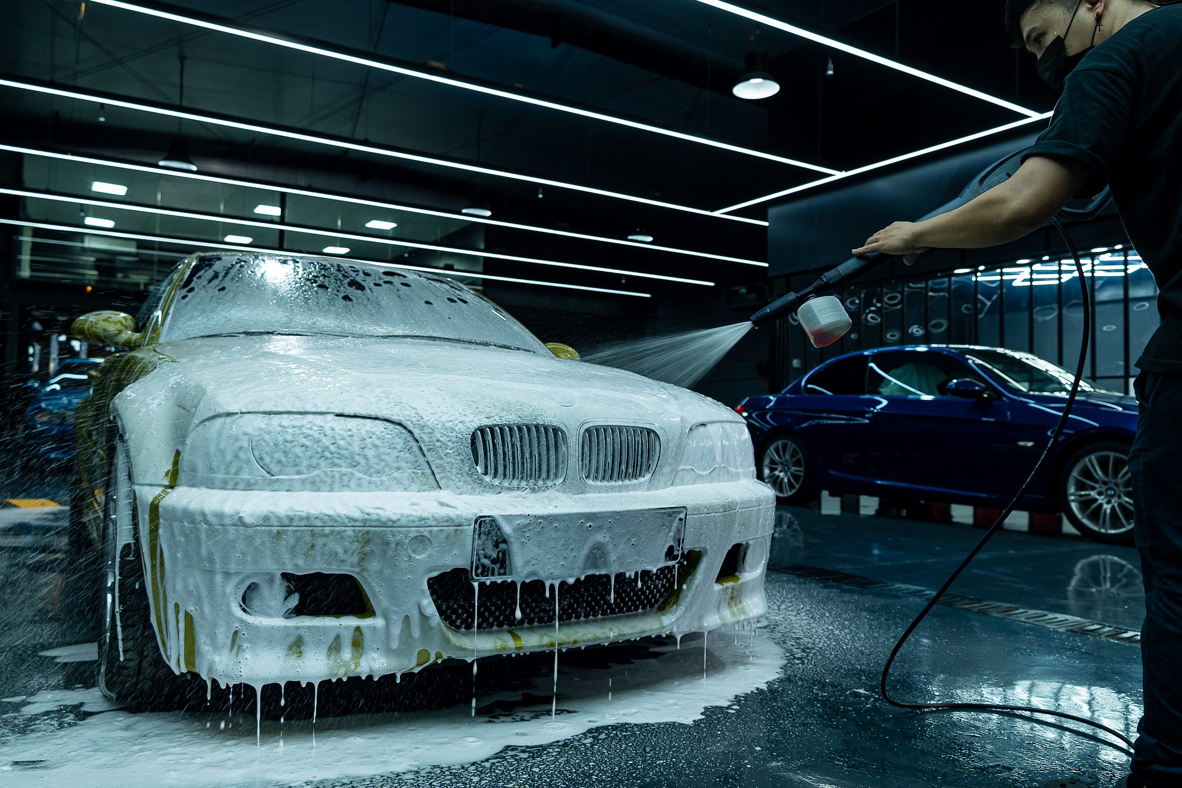 A car covered in snow foam during the wash stage