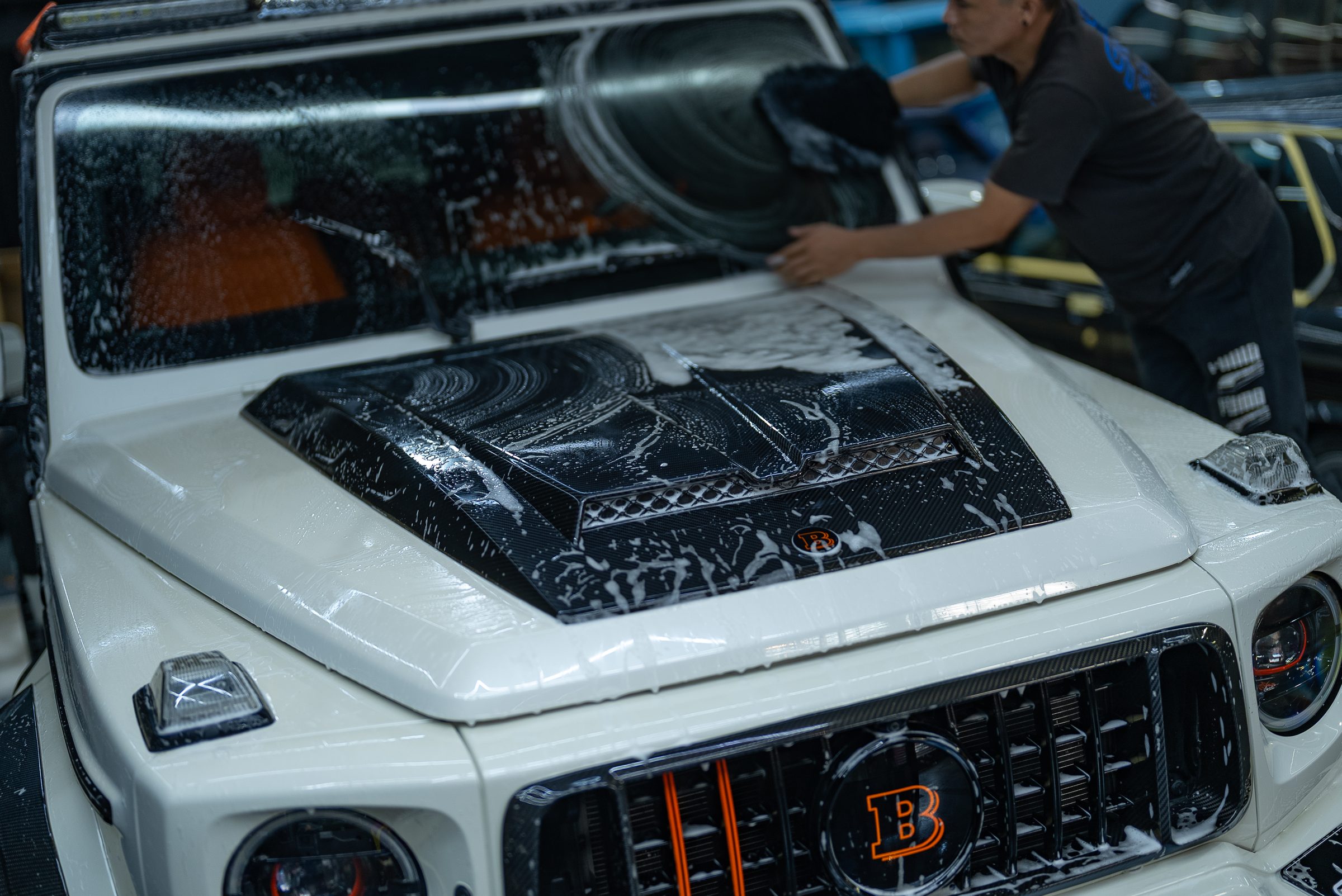 Protection film being fitted to the bonnet of a white Mercedes G-Class