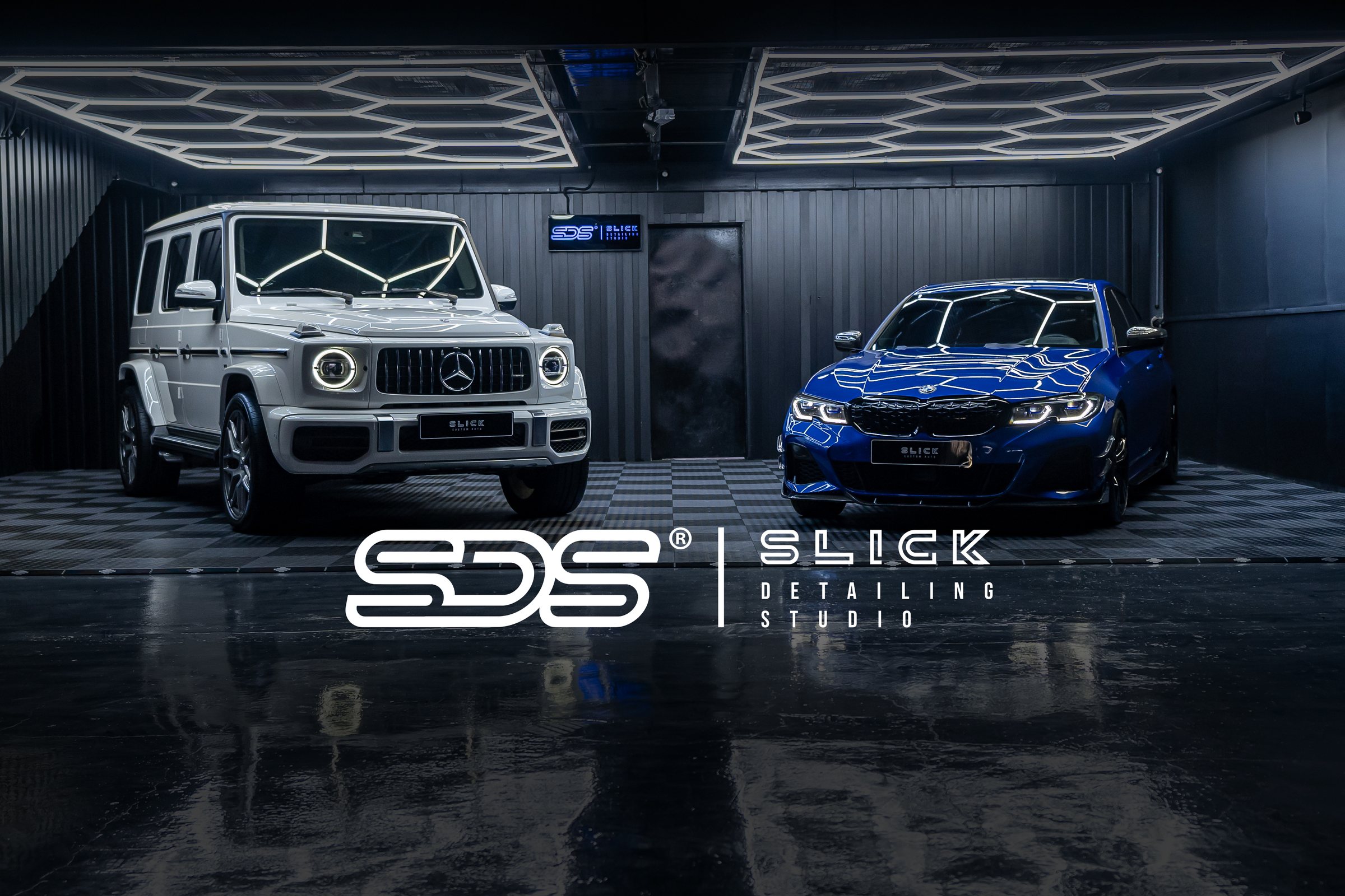 A Mercedes G-Class and a blue BMW under the studio lighting