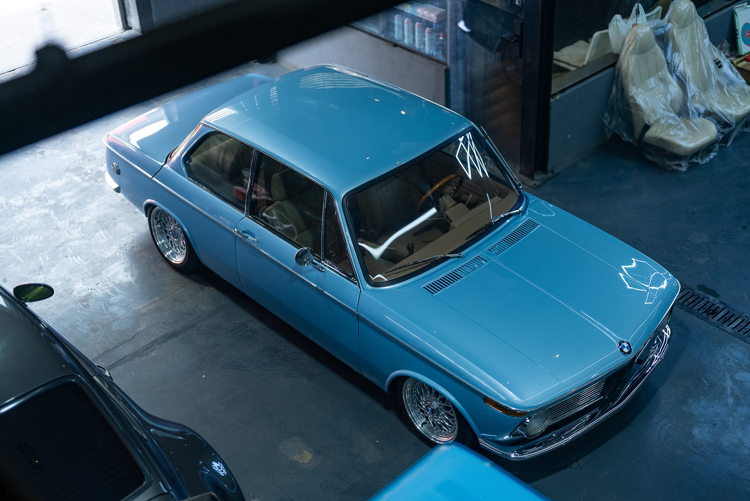 A blue BMW 2002 inside the Slick workshop