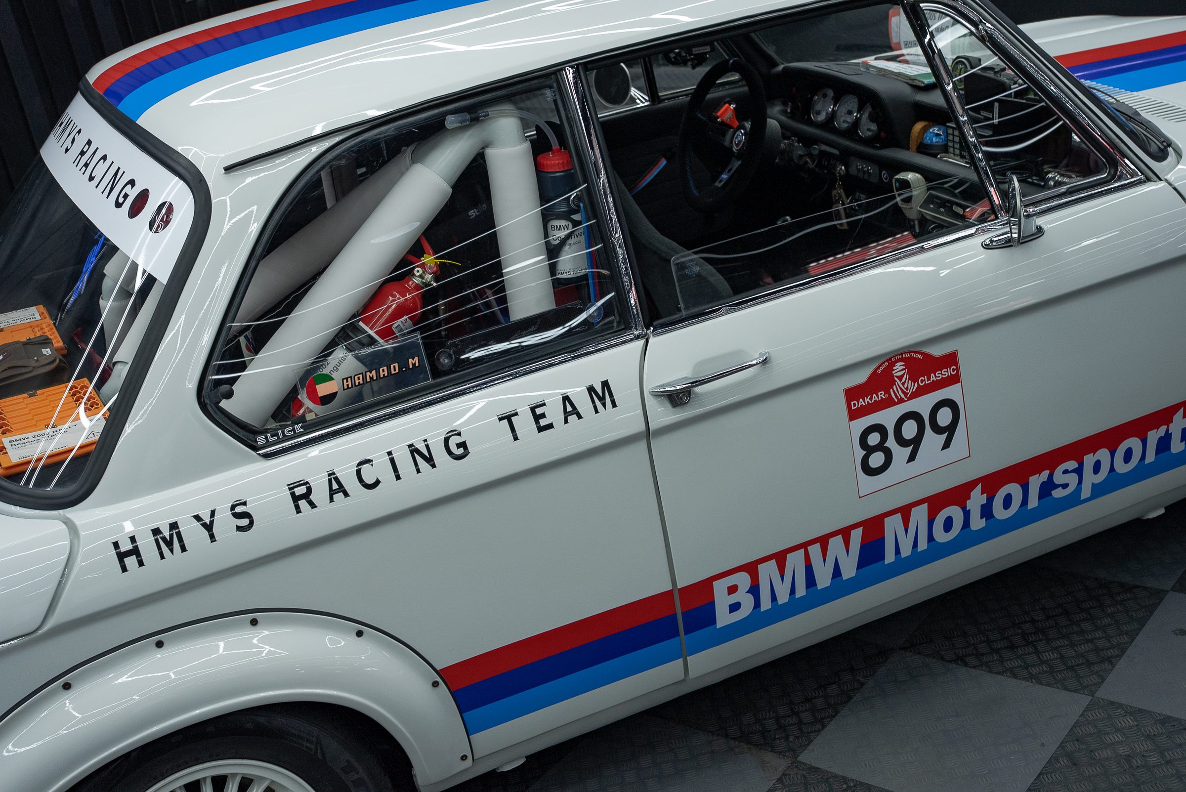 A BMW 2002 in motorsport livery inside the workshop