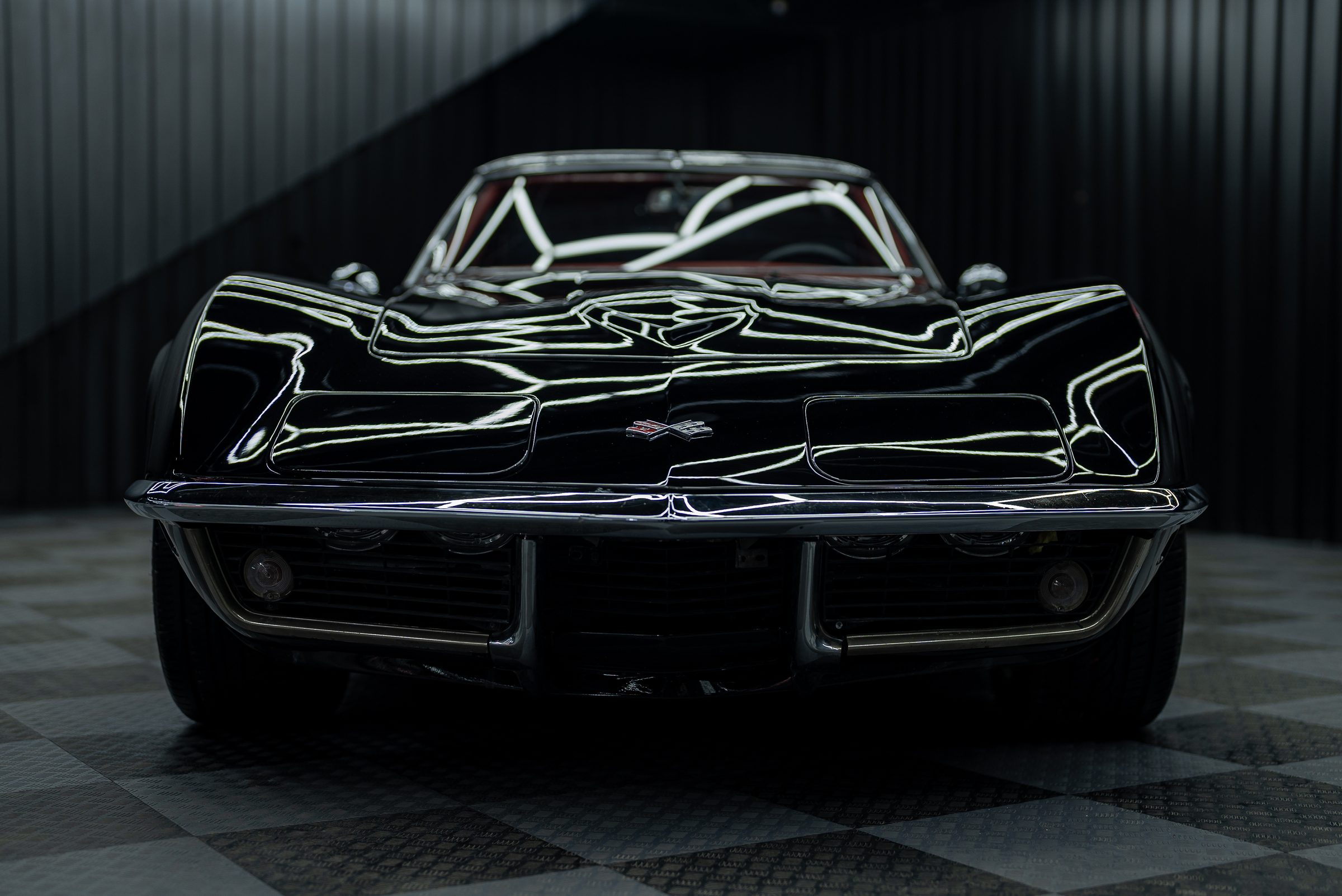A black classic Chevrolet Corvette photographed head-on