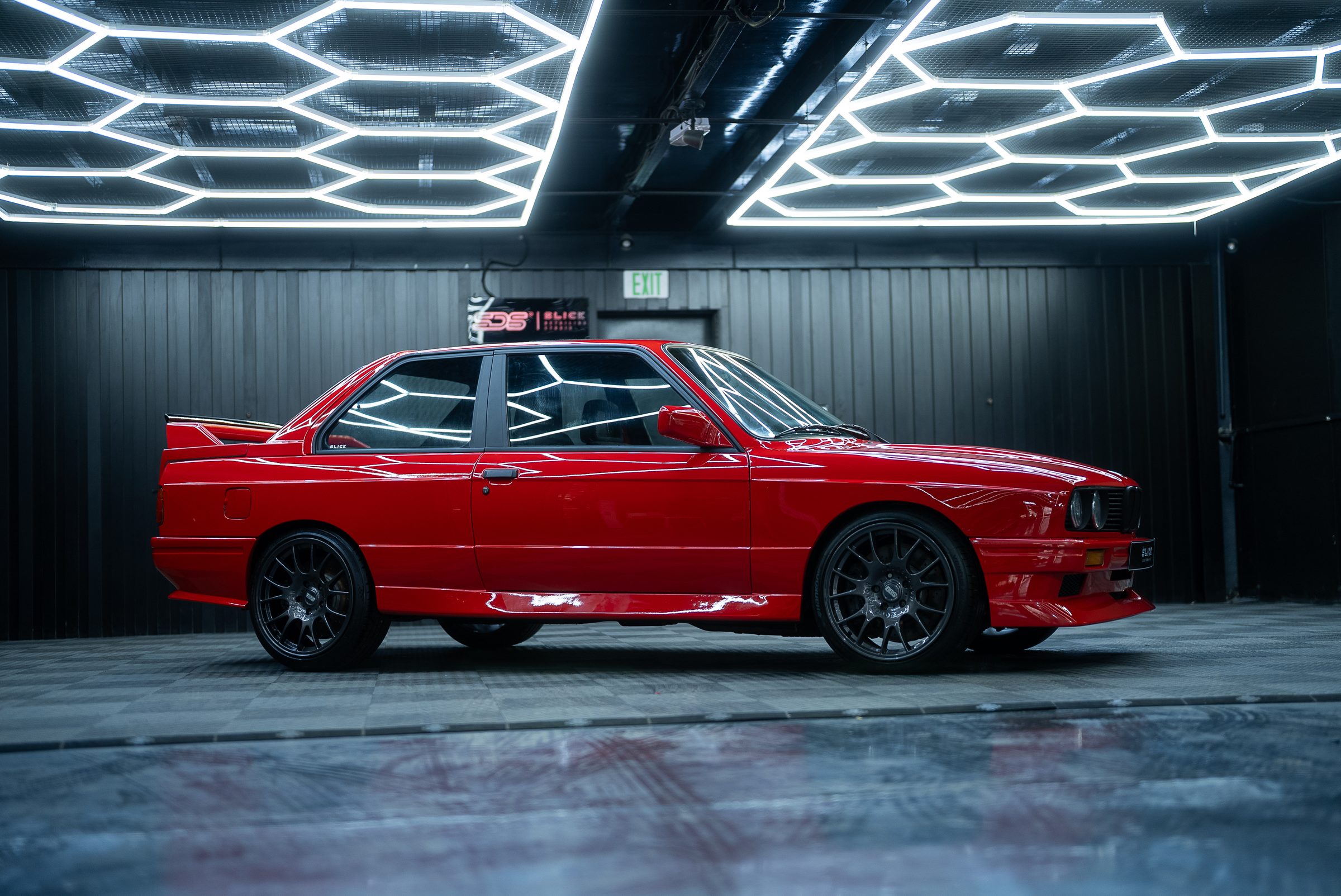 A red BMW M3 E30 in a dark studio
