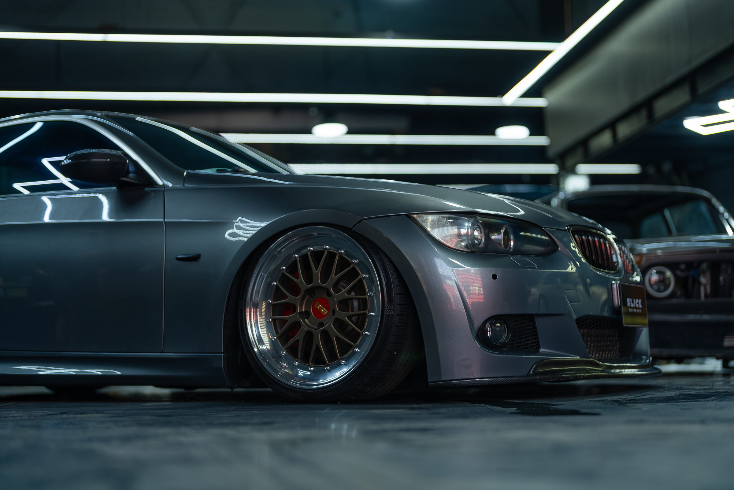 A BMW saloon on the workshop floor under the studio's overhead lighting